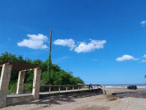 a bridge on the beach with a car on it at Apartment 1 block from the sea in Mar de Ajó
