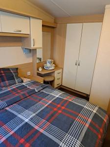 a bedroom with a bed with a plaid blanket at Cozy corner house, New vennepark in De Haan +5 photos