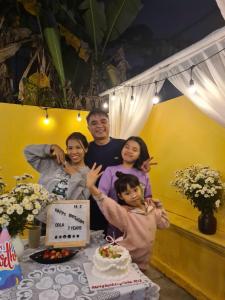 a man and his family standing next to a table with a cake at Snow Homestay in Ninh Binh