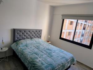 a bedroom with a bed and a window at Apartment 1 block from the sea in Mar de Ajó