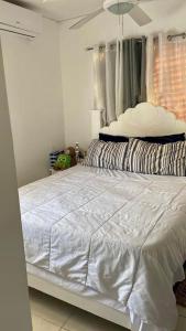 a bedroom with a white bed with a white comforter at Apartment in a comfortable and quiet area in Pantoja