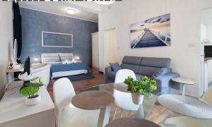 ein Wohnzimmer mit Sofa, Bett und Tisch in der Unterkunft HOME EXPERIENCE in Bari
