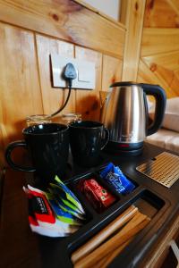 a stove top with two cups and a tea kettle at Jawai Himalayan Cottage in Vashisht +32 photos