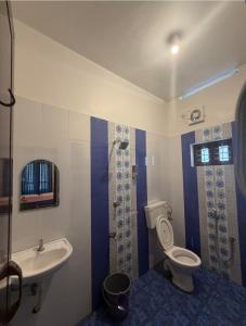 a bathroom with a toilet and a sink at Villa mud apples varkala in Varkala