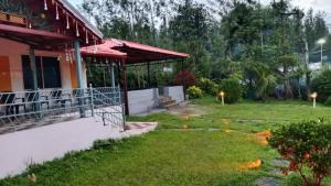a porch of a building with a grass yard at Malnad Mist in Attigundi