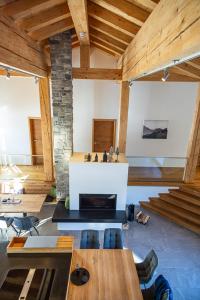 a large room with a fireplace and wooden ceilings at Chalet Zaferna in Mittelberg