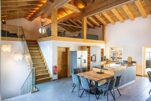 a kitchen with a wooden ceiling and a table and chairs at Chalet Zaferna in Mittelberg
