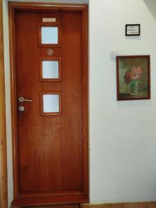 a wooden door in a room with a picture on the wall at Fina Apartman in Leskovac