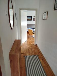 a hallway leading to a living room with a mirror at Fina Apartman in Leskovac +34 photos