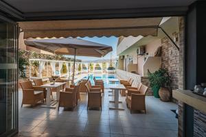a patio with tables and chairs and a pool at Cloud9 Hotel Shisha & Cocktail Bar - Adults Only in Malia