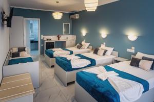 a hotel room with three beds and a bathroom at Cloud9 Hotel Shisha & Cocktail Bar - Adults Only in Malia +27 photos