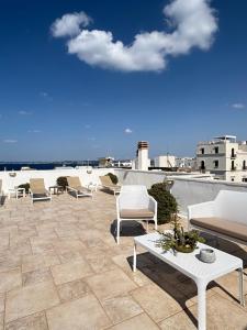 a patio with chairs and a table on a roof at Faro Bianco Gallipoli - Suites & Apartments in Gallipoli