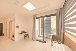 a living room with a table and a large window at World Sky Residence Hotel in Sokcho