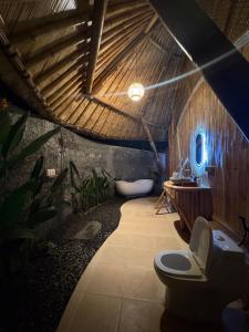 a bathroom with a toilet and a bath tub at Bamboo Garden Villa Sidemen - Private Pool & Nature View in Selat +82 photos