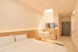 a bedroom with a bed and a table and a tv at World Sky Residence Hotel in Sokcho +46 photos