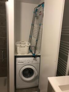 a laundry room with a washing machine and mop at Appartement récent et à la déco moderne in Damgan +2 photos