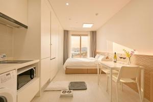 a kitchen and a bedroom with a bed and a table at World Sky Residence Hotel in Sokcho