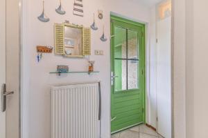 a green door in a hallway with a mirror at Vakantiehuis Miriam op park Strandslag Julianadorp aan Zee in Julianadorp