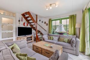 a living room with two couches and a staircase at Vakantiehuis Miriam op park Strandslag Julianadorp aan Zee in Julianadorp