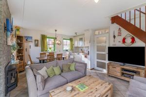 a living room with a couch and a tv at Vakantiehuis Miriam op park Strandslag Julianadorp aan Zee in Julianadorp