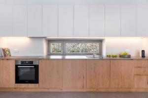 a kitchen with wooden cabinets and a window at Lithi House in Grionísi