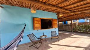 a patio with two chairs and a tv on a blue wall at Casa do Brother in Prado
