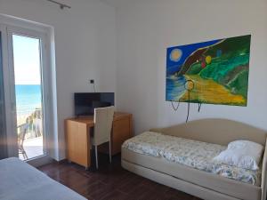 a bedroom with a bed and a desk and a painting at Villa Nettuno in San Menaio