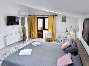 a bedroom with a large bed and a couch at Casa Cernica in Cernica