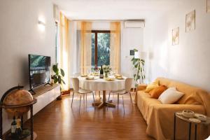 a living room with a couch and a table at Attico panoramico, a pochi passi dal mare, due parcheggi interni inclusi in Milano Marittima