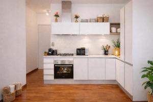 a kitchen with white cabinets and a stove at Attico panoramico, a pochi passi dal mare, due parcheggi interni inclusi in Milano Marittima