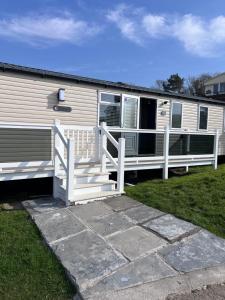 a mobile home with a porch and a white railing at 107 Arran View with WiFi in Ayr