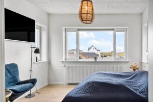 a bedroom with a blue bed and a window at 717-Thyboron-Jernbanegade-3 in Thyborøn