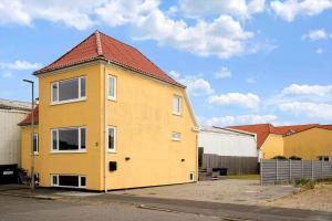 a yellow house with a red roof on a street at 717-Thyboron-Jernbanegade-3 in Thyborøn