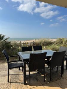 a table and chairs on a patio with the beach at Appartement La plage in Berck-sur-Mer