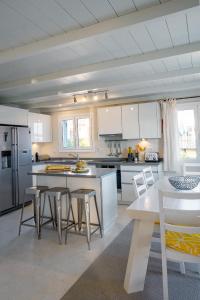 a kitchen with white cabinets and a table and chairs at Irini's Bayside Loft in Fiskardo
