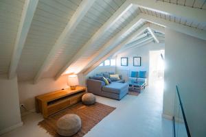 a living room with a blue couch and a table at Irini's Bayside Loft in Fiskardo
