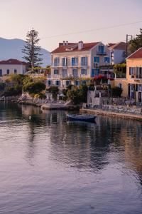 a boat in the water in front of some houses at Irini's Bayside Loft in Fiskardo