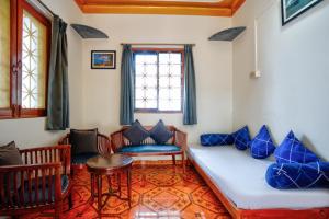 a living room with blue pillows and a couch at Anjuna Beach House in Anjuna