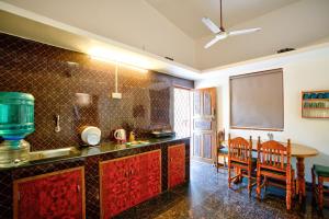 a kitchen with a counter and a dining room with a table at Anjuna Beach House in Anjuna