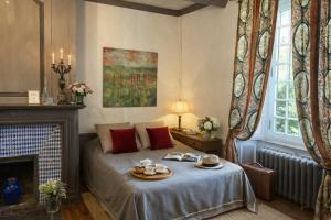 a bedroom with a bed and a fireplace at Chateau d'Isigny - Normandie - Country House in Isigny-le-Buat