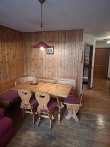 a wooden dining room with a wooden table and chairs at Campiglio Trilocale Cima Tosa in Madonna di Campiglio
