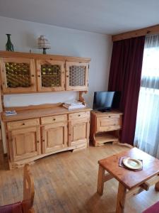 a living room with wooden cabinets and a table at Campiglio Trilocale Cima Tosa in Madonna di Campiglio