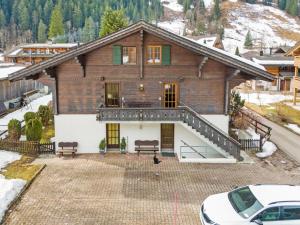 an aerial view of a house with a car parked in front at Chalet-Apartment mit Balkon & Gratis Parkplatz in Lenk
