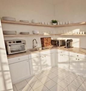 a kitchen with white cabinets and a sink at Motel Seal Rock in Perce
