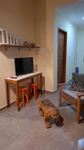 a living room with a desk and a dog on the floor at Casa do Brother in Prado
