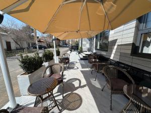 an outdoor patio with tables and chairs and an umbrella at NINETY boutique hotel in Yakkasaray