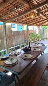 a wooden table with plates and wine glasses on it at Casa do Brother in Prado +3 photos