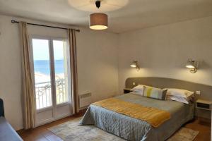a bedroom with a bed and a large window at Le Panoramic in Saint-Florent