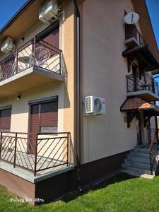 a building with two balconies and a air conditioner at Sobe IVANA in Gornja Toplica