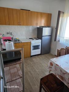 a kitchen with a white stove and a refrigerator at Sobe IVANA in Gornja Toplica
